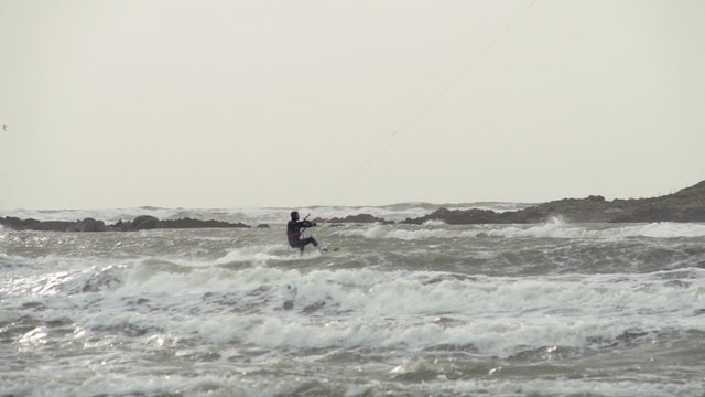 Kite surfers are surfing on large storm waves in North Wales as a stormy winter hits.