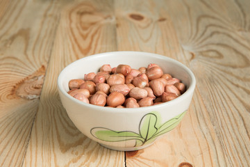 bowl of peanut on a wooden background