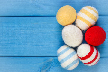 Easter eggs wrapped woolen string on blue wooden boards, copy space for text, decoration for Easter