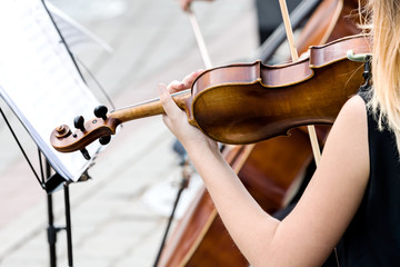 young woman playing the violin at street concert