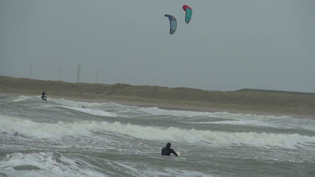 Kite surfers are surfing on large storm waves in North Wales as a stormy winter hits.