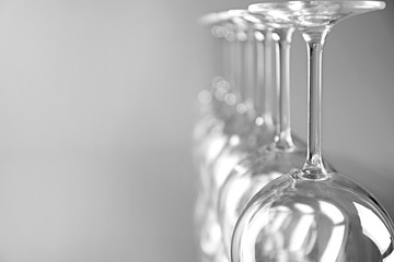 Wine glasses in a row upside down on light grey background
