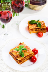 Piece of tasty hot lasagna with red wine..