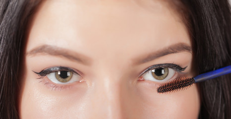 woman paints the eyelashes mascara