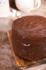 Chocolate cake with blade on a wooden boards background