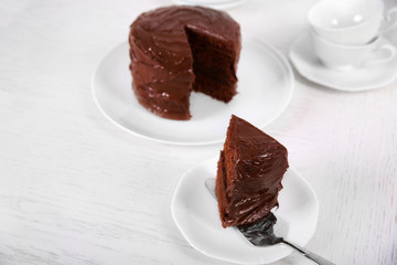 Chocolate cake on plates with a cut piece on unfocused background