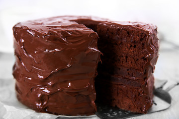 Chocolate cake with a cut piece on wooden table background, closeup