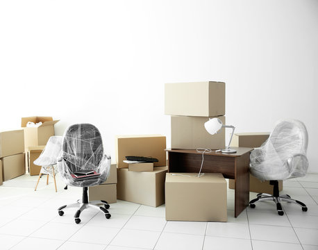 Moving cardboard boxes and personal belongings in empty office space