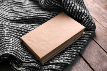 A book and a woolen blanket on the floor, close-up