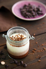 Delicious vanilla-chocolate mousse on wooden background, close up