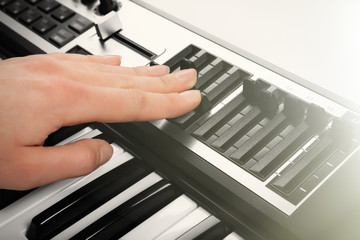 Male hand playing of synthesizer closeup