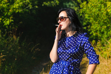 Smoking young lady wearing long dress