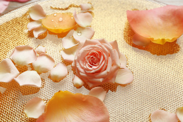 Fototapeta na wymiar Pink and yellow rose petals in golden bowl with water, close up