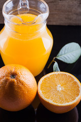 pitcher of fresh orange juice on black table