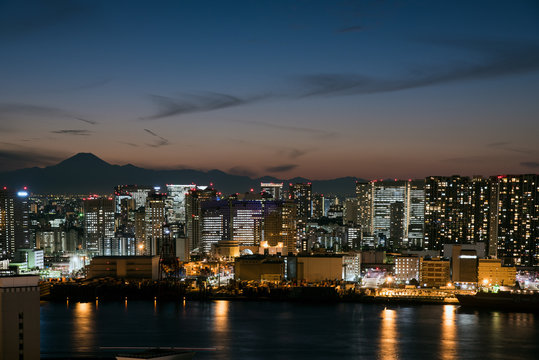 夕暮れ時の富士山と都心のビル群
