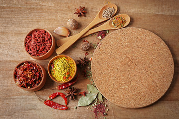 Assorted spices on wooden table, top view