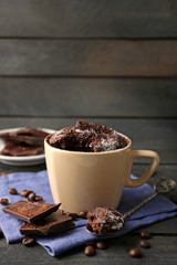 Chocolate fondant cake in cup on wooden background