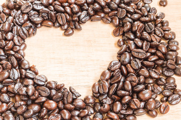 Coffee beans in heart shape  on wooden background