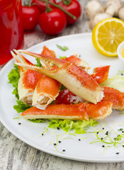 Boiled crab claws with sauce , lemon and cherry tomatoe over wooden background