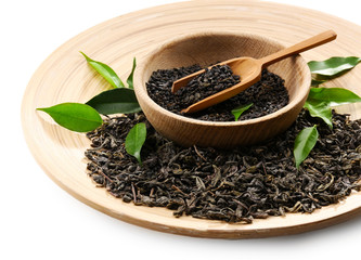 Dry tea with green leaves in wooden utensil, close up