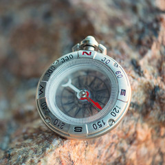 Compass on the beach. Tourist equipment as a background..