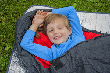 little girl camping with sleeping bag