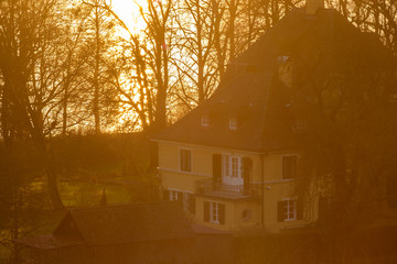 D, Bodensee, Hagnau, Villa am Ufer unter kahlen Bäumen in gelbes, warmes Sonnenlicht getaucht