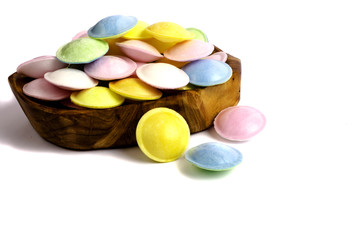 Colorful candy in wooden dish.