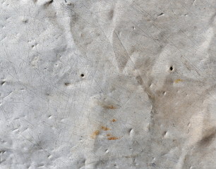 Aged silver holey metal texture. Old iron background