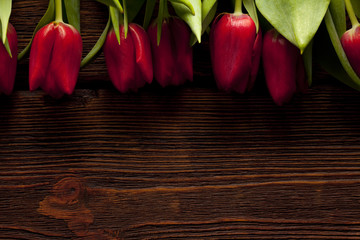 Naklejka na ściany i meble Red tulips on wooden table