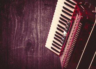 Part red accordion on wooden grey background. Write text. Vintage - obrazy, fototapety, plakaty