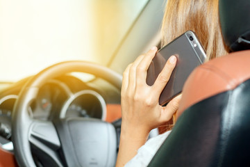 Asian women are driving cars and using a smartphone on the road.