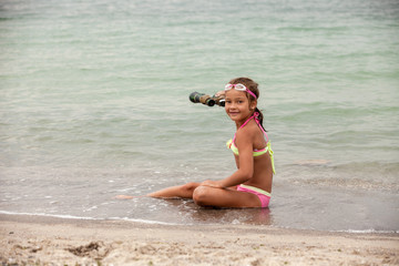 Little cute girl with binoculars outdoor