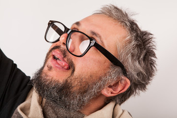 Crazy looking old man with grey beard nerd big glasses show tongue