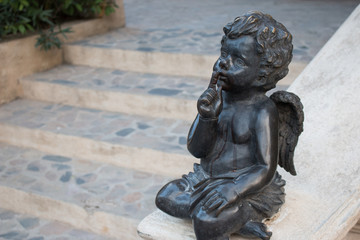 Fototapeta na wymiar Cupid statue sitting