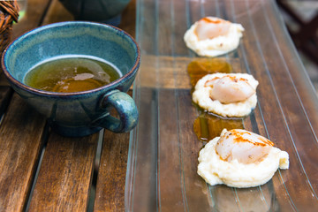Close up of pan seared sea scallops and a cup of cider