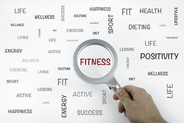 Sheet with text and magnifier enlarging word Fitness