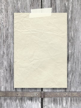 Close-up of one old vintage paper sheet with adhesive tape on weathered wooden boards background