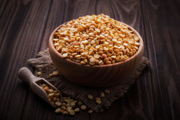 Yellow dry peas in wooden bowl
