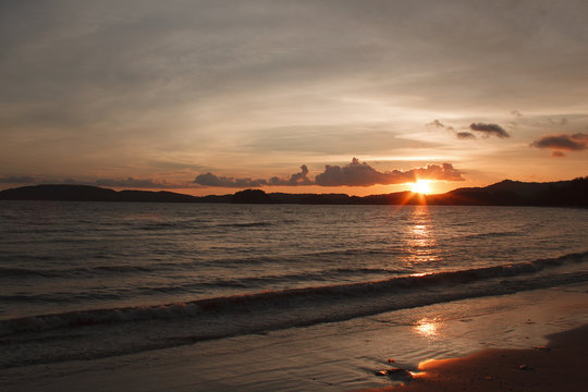 Sun sets over the mountain and sea
