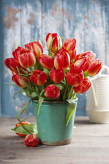 Beautiful tulips bouquet and garden tools on wooden table