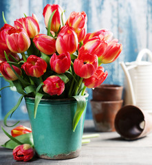 Beautiful tulips bouquet and garden tools on wooden table
