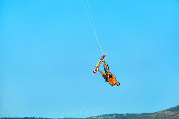 Fototapeta premium Extreme Water Sport. Kiteboarding, Kitesurfing Action. Professional Kiter Makes Difficult Trick In Air. Active Lifestyle. Hobby. Recreational Sporting Activity. Sports. Summer Fun, Adventure.