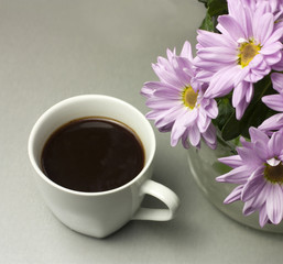 Black coffee with bouquet of tender pink chrysanthemums