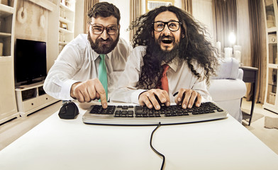 Two nerdy guys working with a computer - obrazy, fototapety, plakaty