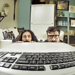 Stoff pro Meter Zwei lustige Computerwissenschaftler, die entlang einer Tastatur anstarren © konradbak