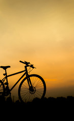 Fototapeta na wymiar Sunset silhouette and bicycle on beautiful sky