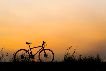 Fototapeta na wymiar Sunset silhouette and bicycle on beautiful sky
