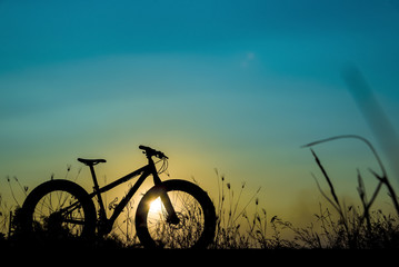 beautiful sunset sky and mountain bike silhouette , silhouette fat bike