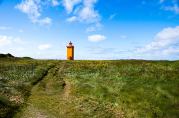 An orange lighthouse seen at the westcoast of Iceland 